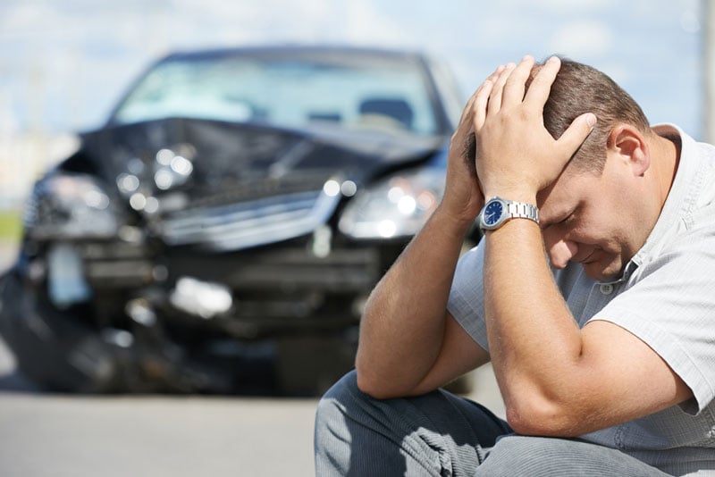 frustrated-man-by-wrecked-vehicle
